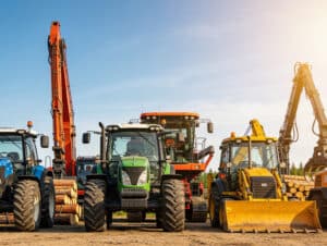 Heavy equipment fleet including tractors, excavators, and loaders representing the need for connected modular ERP and CRM across equipment dealer operations